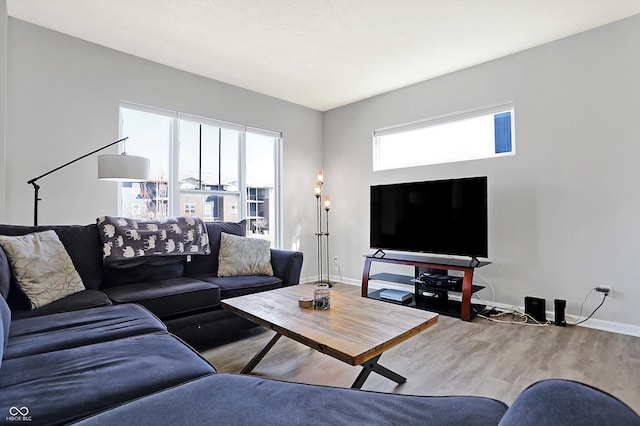 living room featuring plenty of natural light, wood finished floors, and baseboards