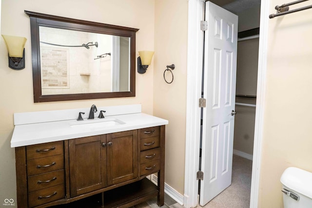 bathroom with toilet, baseboards, and vanity