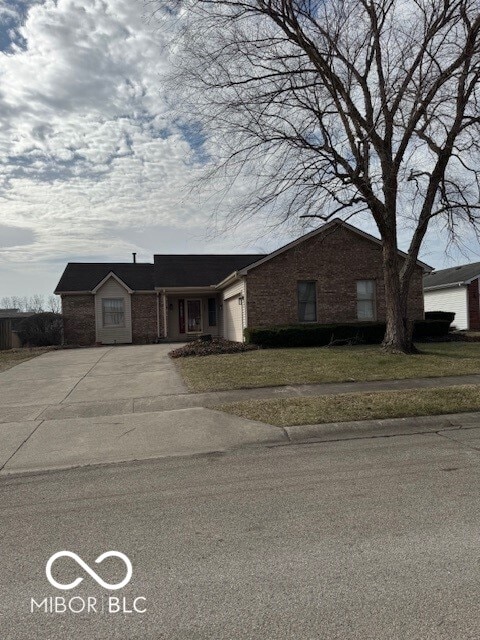 ranch-style home featuring a garage, concrete driveway, and brick siding