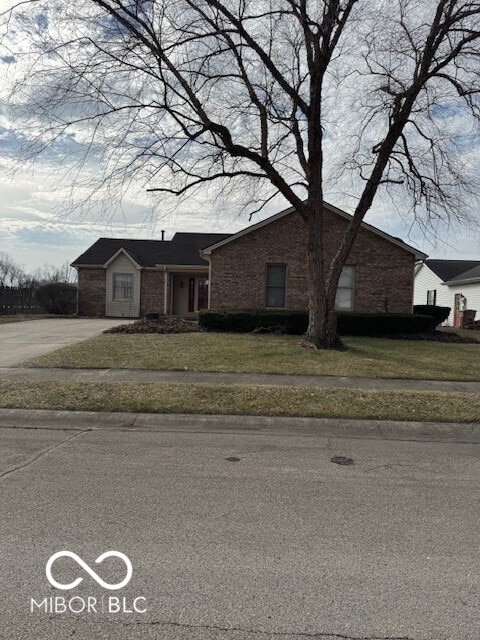 view of front of home with brick siding and a front yard