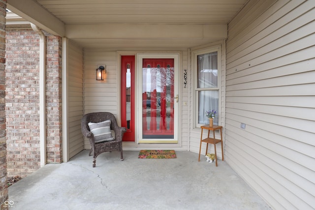 property entrance featuring brick siding and a porch