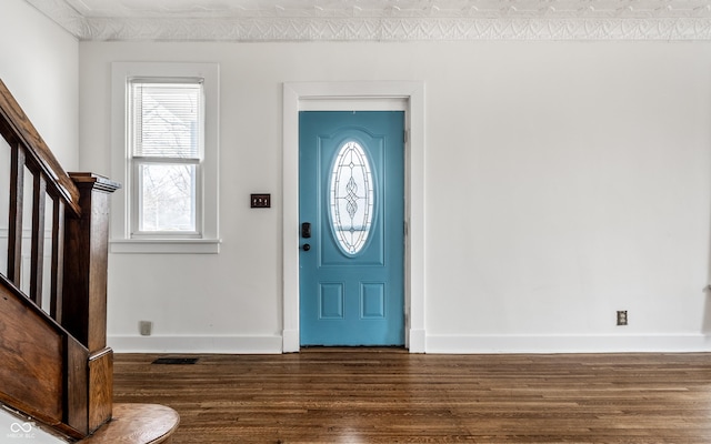 foyer with dark wood-style floors, baseboards, and stairs