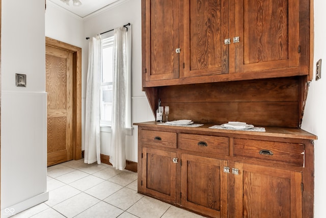 interior space with ornamental molding and light tile patterned flooring