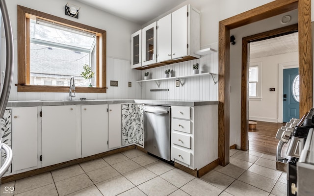 kitchen featuring open shelves, gas stove, white cabinetry, a sink, and dishwasher