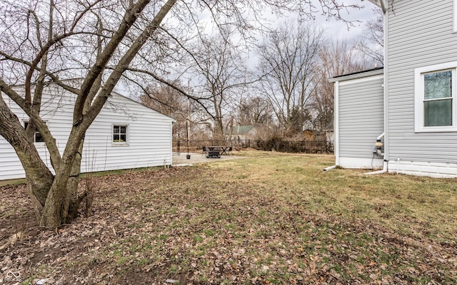 view of yard with fence, a fire pit, and a patio