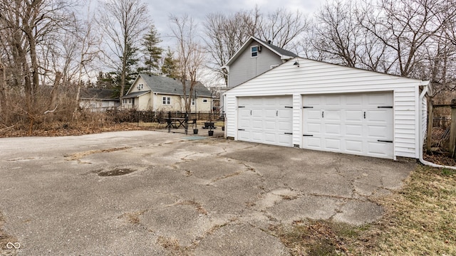 garage with driveway and fence