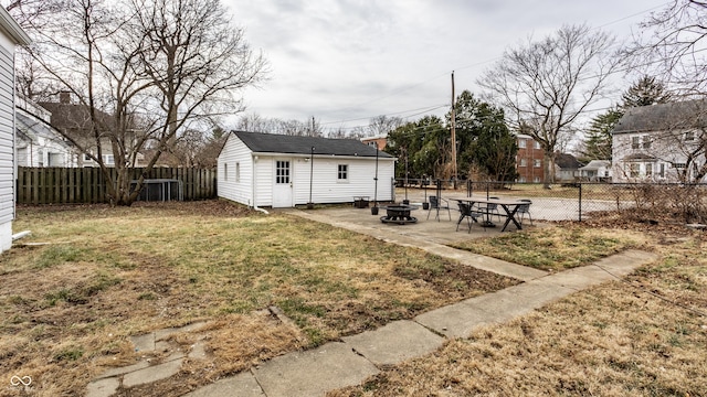 exterior space with an outbuilding, a patio, an outdoor fire pit, and a fenced backyard