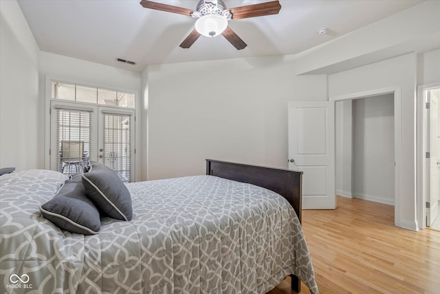 bedroom featuring access to exterior, visible vents, light wood-style floors, ceiling fan, and baseboards