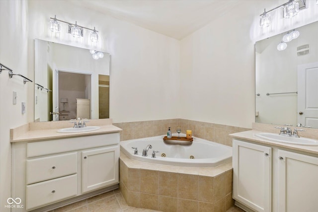 full bathroom with a tub with jets, two vanities, a sink, and tile patterned floors