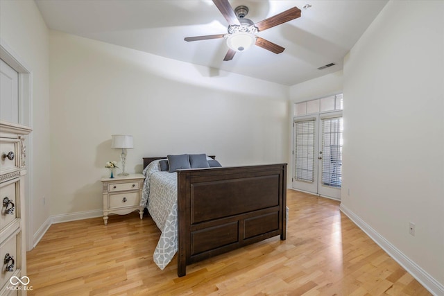 bedroom featuring baseboards, a ceiling fan, visible vents, and light wood-style floors