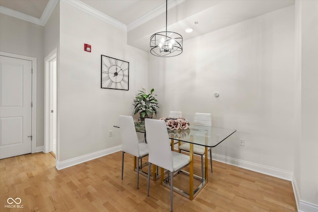 dining space with ornamental molding, light wood-type flooring, a chandelier, and baseboards