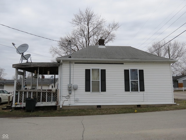 view of front of property with a shingled roof, crawl space, and a chimney