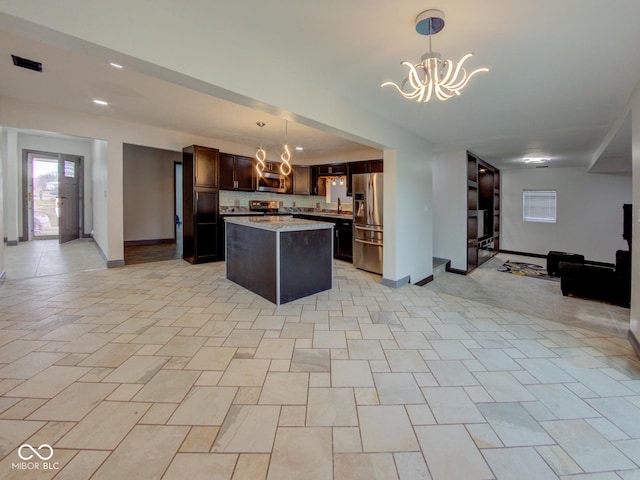 kitchen with stainless steel appliances, open floor plan, light countertops, and a notable chandelier