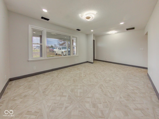 spare room featuring baseboards, visible vents, and recessed lighting