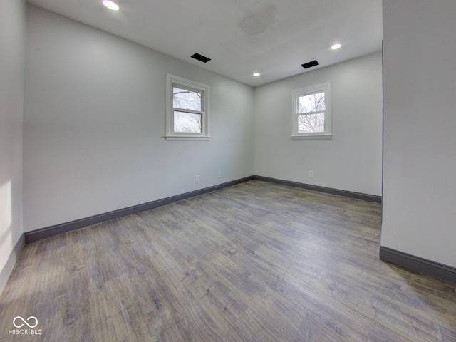 empty room with recessed lighting, visible vents, baseboards, and wood finished floors