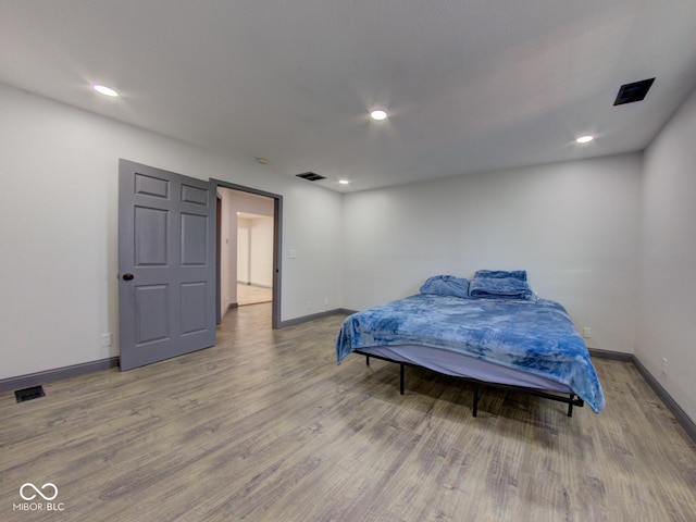 bedroom with recessed lighting, visible vents, baseboards, and wood finished floors