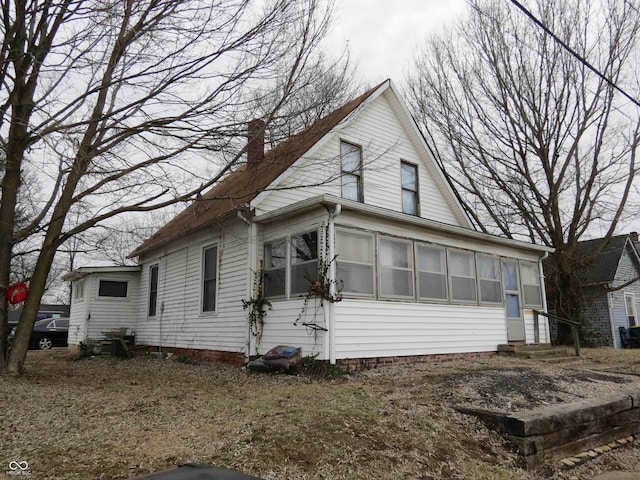 view of home's exterior featuring entry steps and a chimney