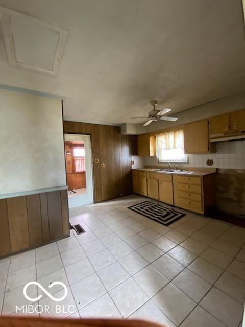 kitchen with wood walls, plenty of natural light, visible vents, and a sink