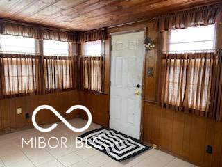 foyer entrance with wooden ceiling and wood walls