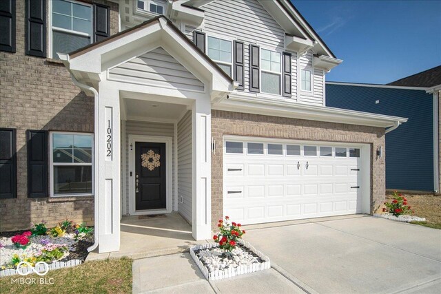 10202 Meadow Path Ln, Indianapolis, IN 46239 - entrance to property with driveway, a garage, and brick siding