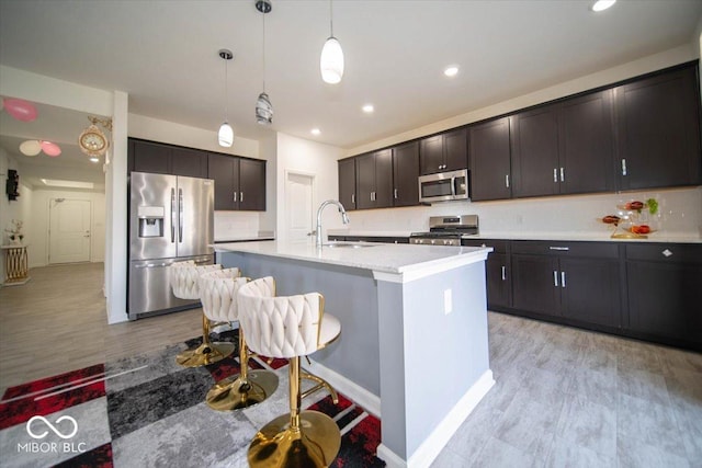 10202 Meadow Path Ln, Indianapolis, IN 46239 - kitchen featuring appliances with stainless steel finishes, a sink, decorative backsplash, a kitchen bar, and pendant lighting