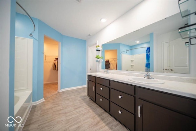 10202 Meadow Path Ln, Indianapolis, IN 46239 - bathroom with a walk in closet, double vanity, and baseboards