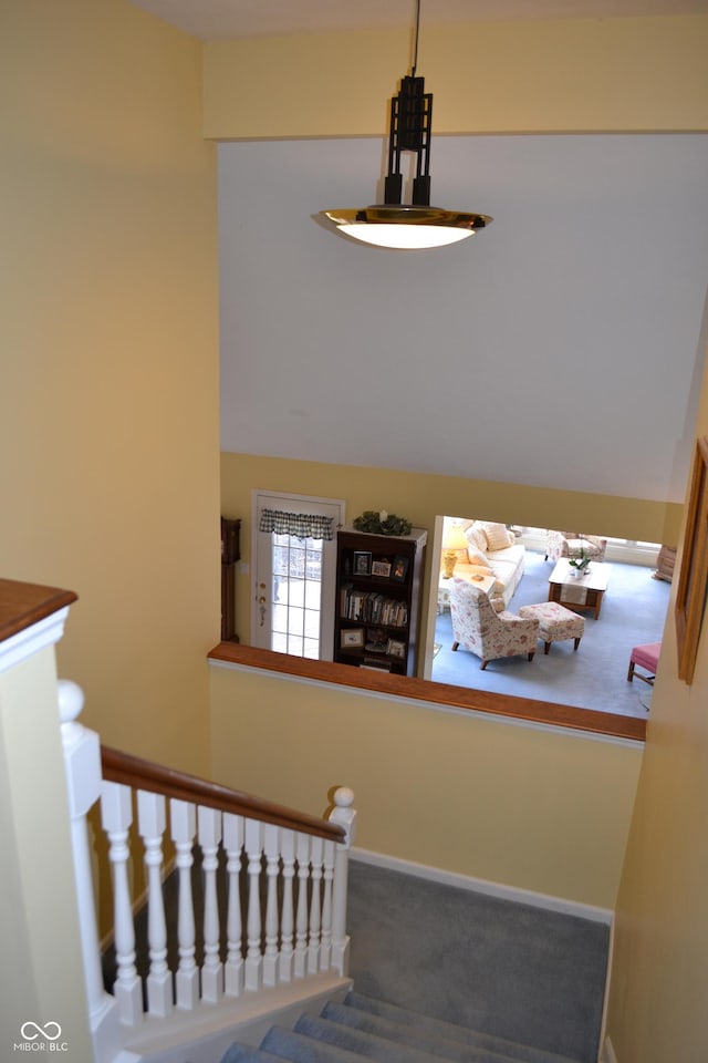 staircase featuring carpet floors and baseboards