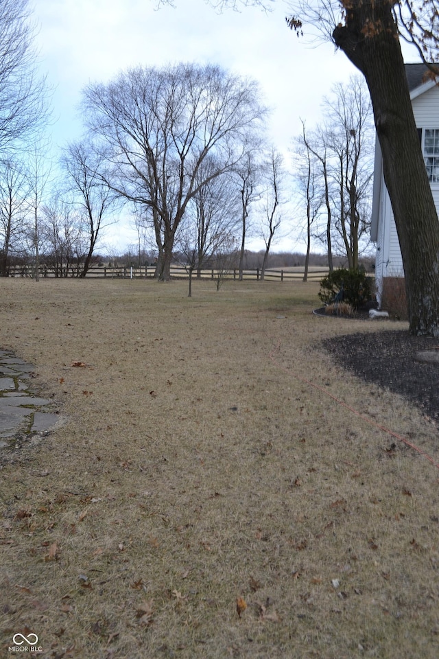 view of yard with fence and a rural view