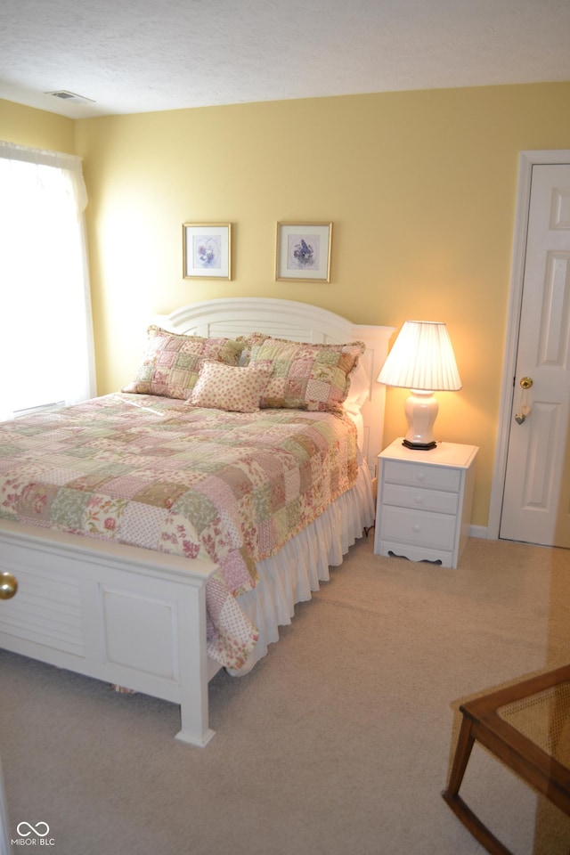 bedroom with visible vents and light colored carpet