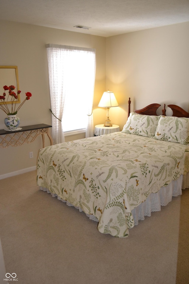 carpeted bedroom featuring visible vents and baseboards