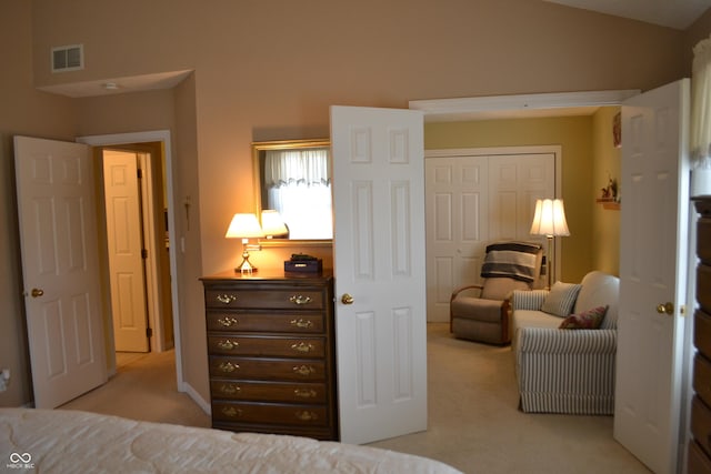 bedroom with light colored carpet, a closet, visible vents, and vaulted ceiling