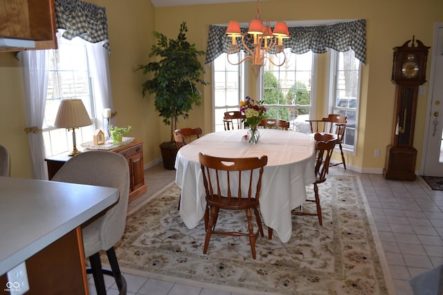 dining space featuring a chandelier, baseboards, and light tile patterned floors