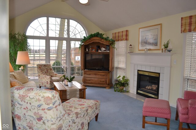 carpeted living room featuring lofted ceiling, a fireplace, and a ceiling fan