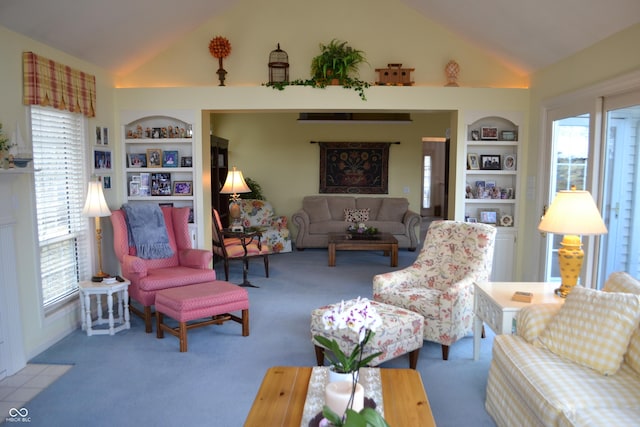 carpeted living area featuring a healthy amount of sunlight, high vaulted ceiling, and built in features