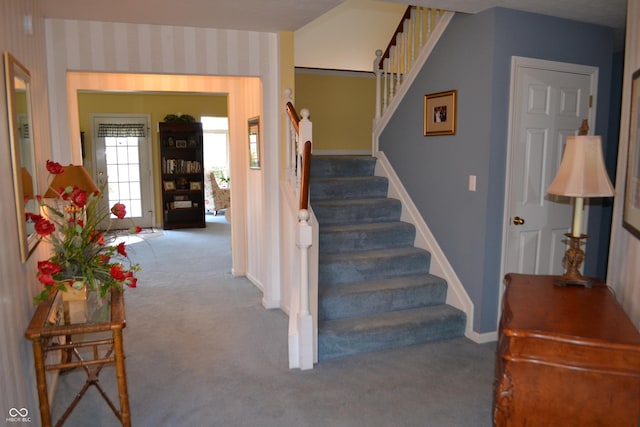 stairway featuring wallpapered walls, baseboards, and carpet flooring