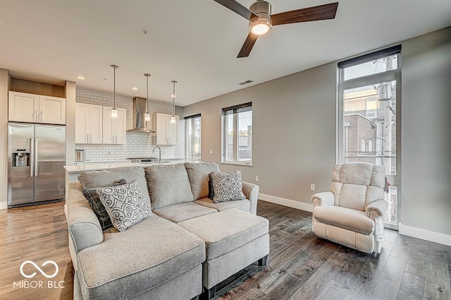 living area with visible vents, baseboards, and wood finished floors