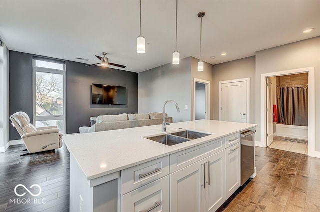 kitchen featuring white cabinets, dark wood-style floors, visible vents, and a sink