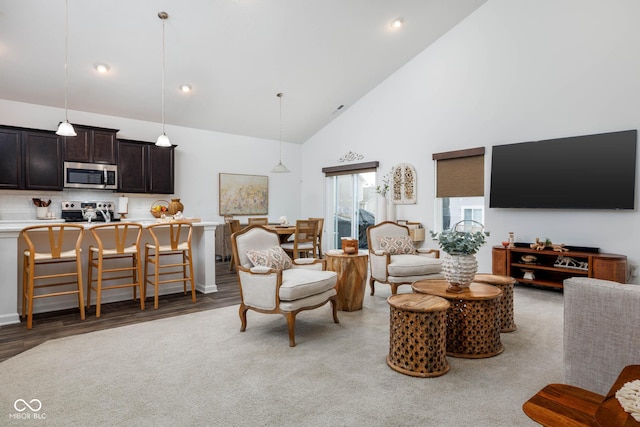 living room with high vaulted ceiling, light wood-type flooring, and recessed lighting