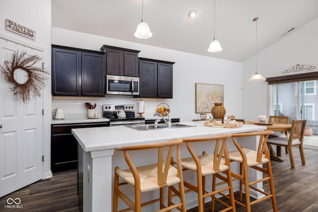 kitchen with stainless steel appliances, light countertops, dark wood finished floors, and tasteful backsplash