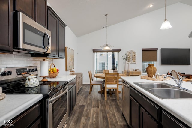 kitchen with a sink, light countertops, appliances with stainless steel finishes, dark brown cabinets, and dark wood finished floors