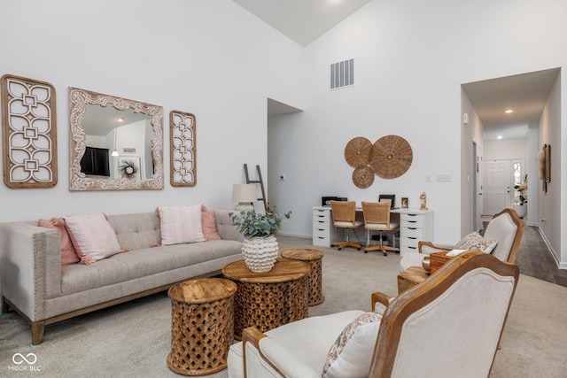 carpeted living area with recessed lighting, visible vents, a towering ceiling, and baseboards