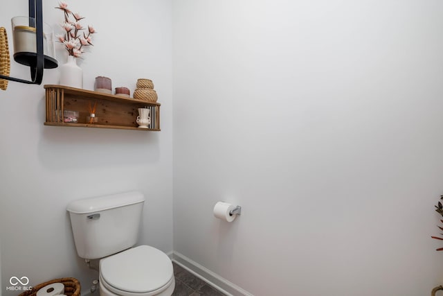 bathroom with toilet, baseboards, and tile patterned floors