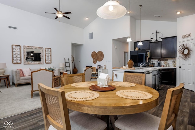 dining area featuring dark wood-type flooring, visible vents, and high vaulted ceiling