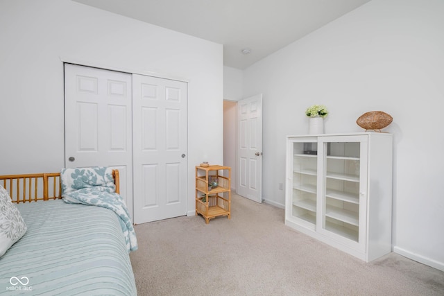 carpeted bedroom featuring a closet and baseboards