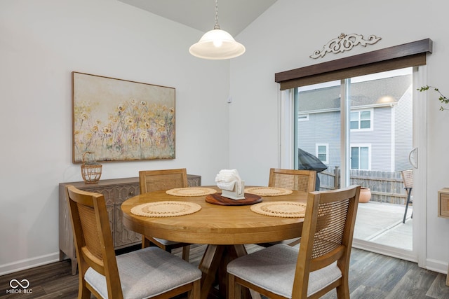 dining room with baseboards, vaulted ceiling, and wood finished floors