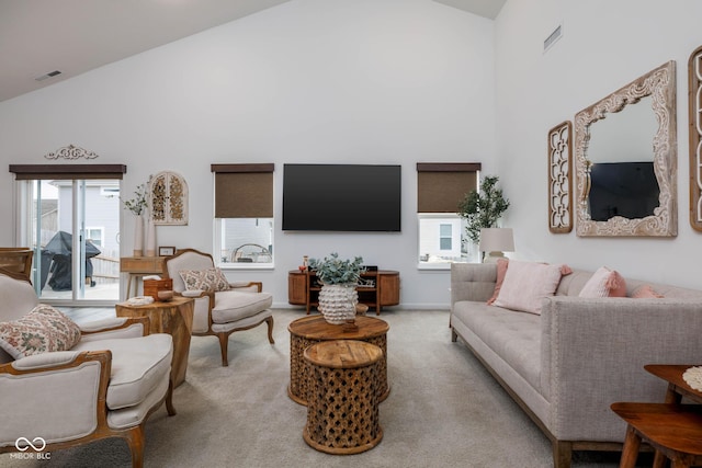 carpeted living room with visible vents, high vaulted ceiling, and baseboards