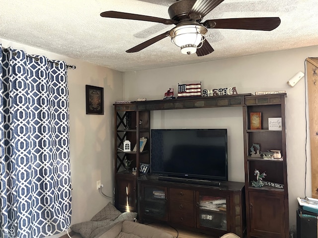 living area featuring ceiling fan and a textured ceiling