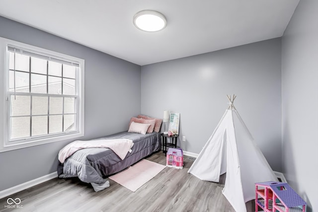 bedroom featuring wood finished floors and baseboards