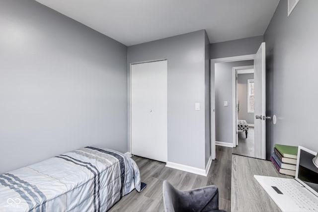 bedroom featuring a closet, baseboards, and wood finished floors