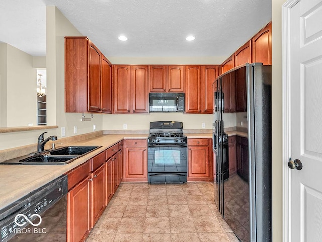 kitchen featuring recessed lighting, a sink, light countertops, black appliances, and brown cabinetry